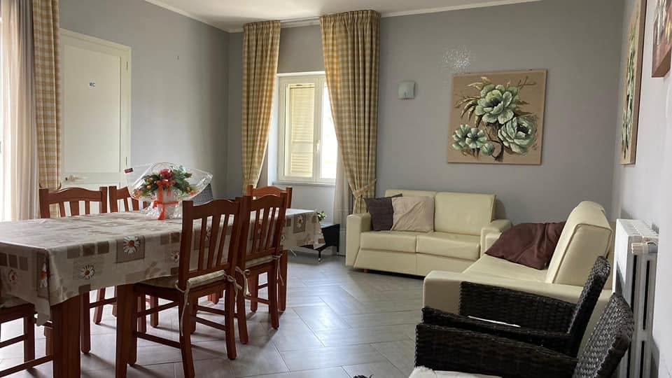 Spazio comune con divani e tavolo da pranzo, Casa Crisalide